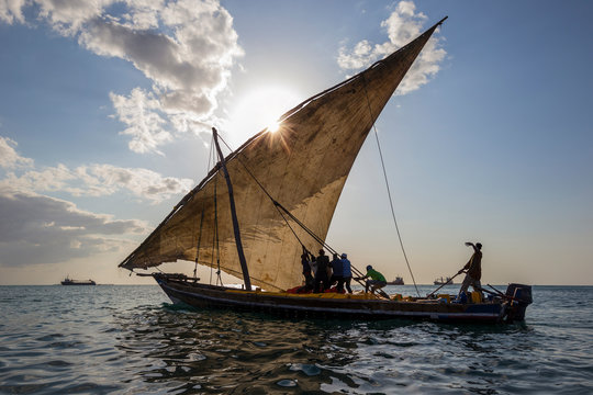 A fishing boat on the ocean at sunset.